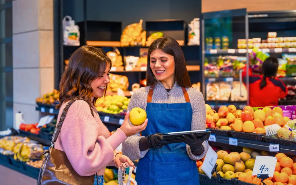 An employee and customer in the food aisle of a supermarket, representing employee mold health concerns
